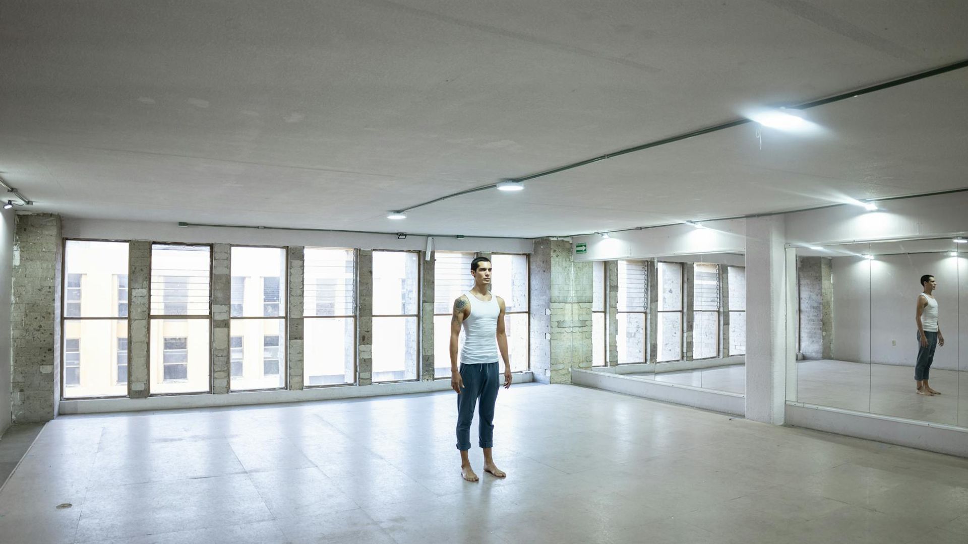 Person practicing yoga in a bright minimalist studio space.